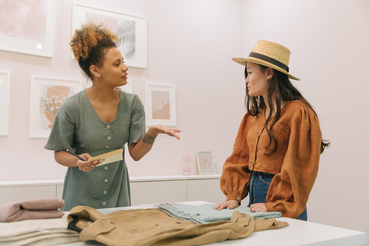 Two women fashion designers discussing and planning together in a stylish indoor setting